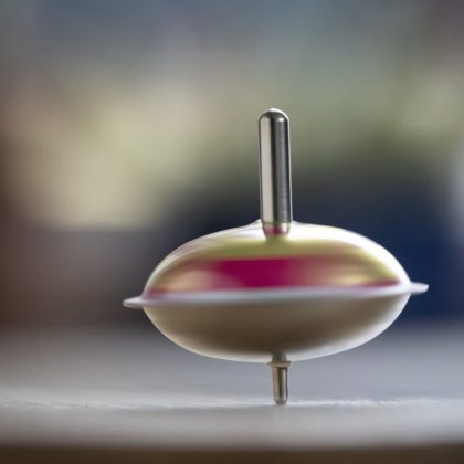 Ein Kreisel befindet sich im Gleichgewicht und dreht auf einer Oberfläche seine Kreise.